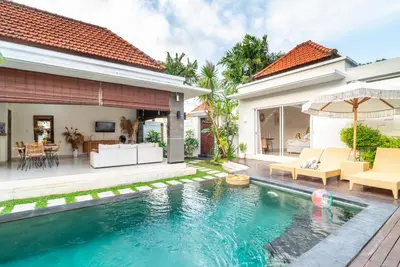 a villa with a swimming pool and a house at Villa Luna Rose in Seminyak