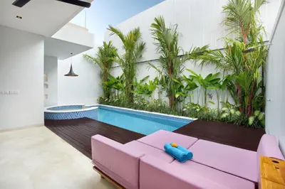 a living room with a pink couch and a swimming pool at Eight Palms Villa Seminyak by Ini Vie Hospitality in Seminyak