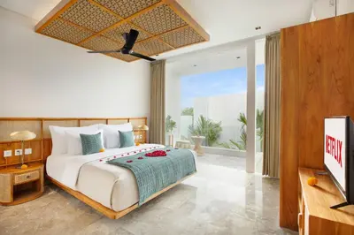 a bedroom with a large bed and a tv at Eight Palms Villa Seminyak by Ini Vie Hospitality in Seminyak