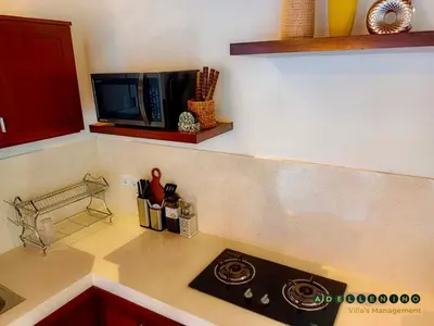 a kitchen counter with a stove and a microwave at CASA LUWIH Newly Renovated 2BR Villa with Private Pool in Seminyak in Seminyak