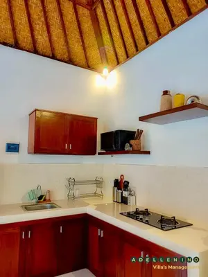 a kitchen with red cabinets and a counter top at CASA LUWIH Newly Renovated 2BR Villa with Private Pool in Seminyak in Seminyak