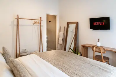 a bedroom with a bed and a desk and a mirror at Casa de Lupe 5 bedroom villa in Kerobokan in Seminyak