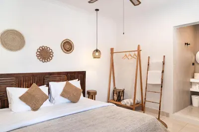 a bedroom with a bed with white sheets and pillows at Casa de Lupe 5 bedroom villa in Kerobokan in Seminyak