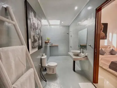 a bathroom with a sink and a toilet in it at CASA BISMA - 3 Bedroom Villa with Pool in LEGIAN in Seminyak