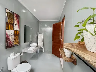 a bathroom with a toilet and a sink at CASA BISMA - 3 Bedroom Villa with Pool in LEGIAN in Seminyak