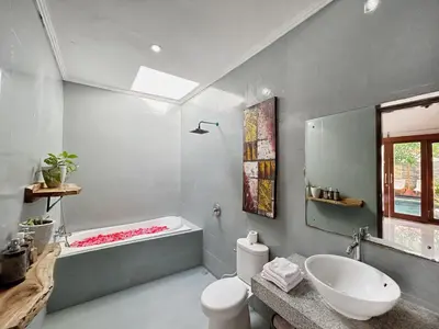 a bathroom with a tub and a toilet and a sink at CASA BISMA - 3 Bedroom Villa with Pool in LEGIAN in Seminyak
