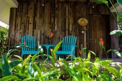 two blue chairs sitting in front of a building at Chanteak Bali - Stone House 1 in Jimbaran