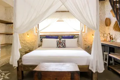 a bedroom with a bed with a canopy at Chanteak Bali - Stone House 3 in Jimbaran