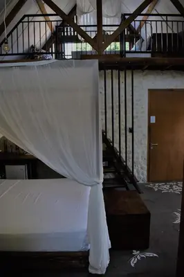 a white canopy in a room with a staircase at Chanteak Bali - Stone House 3 in Jimbaran