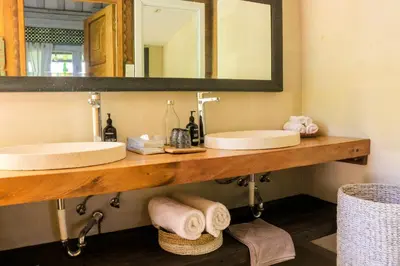 a bathroom with two sinks and a mirror at Chanteak Bali - Teak House 2 in Jimbaran