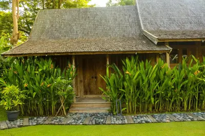 a small house with a wooden door and some plants at Chanteak Bali - Teak House 3 in Jimbaran