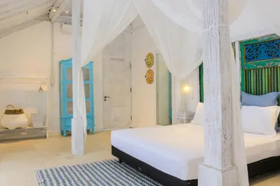 a bedroom with a white bed with a canopy at Chanteak Bali - White House 1 in Jimbaran