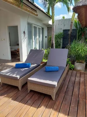 two beds sitting on the deck of a house at Villa bale villa in Seminyak