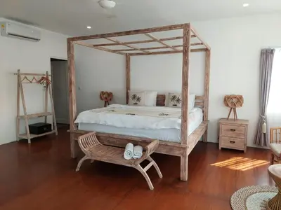 a bedroom with a wooden canopy bed with a bench at Villa bale villa in Seminyak