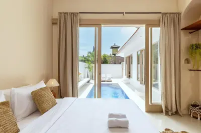 a bedroom with a large bed and a pool at Villa Canggu Beach Coconut - walking distance to Beach & Bars! in Canggu