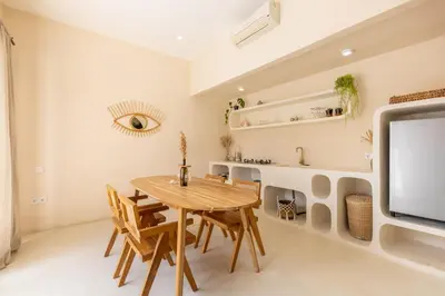 a dining room with a wooden table and a tv at Villa Canggu Beach Coconut - walking distance to Beach & Bars! in Canggu