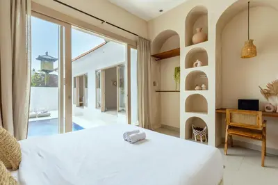 a bedroom with a white bed and a large window at Villa Canggu Beach Coconut - walking distance to Beach & Bars! in Canggu