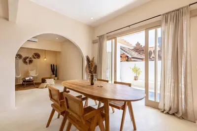 a dining room with a wooden table and chairs at Villa Canggu Beach Coconut - walking distance to Beach & Bars! in Canggu