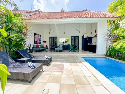 a patio with a swimming pool and a house at Villa Harris Canggu in Canggu