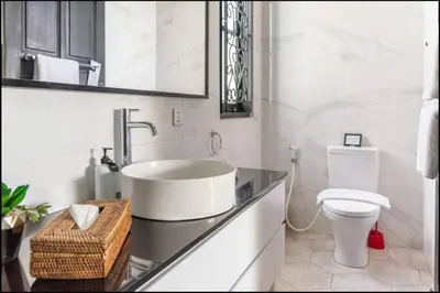 a white bathroom with a sink and a toilet at Villa Harris Canggu in Canggu