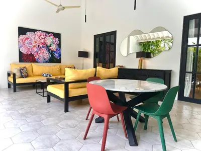 a living room with a couch and a table and chairs at Villa Harris Canggu in Canggu