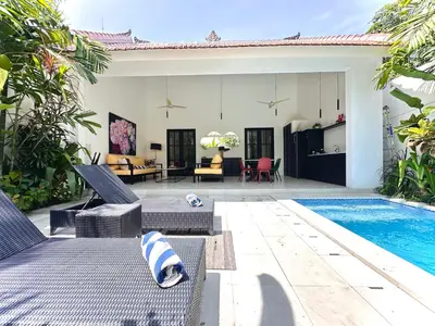 a villa with a swimming pool and a patio at Villa Harris Canggu in Canggu