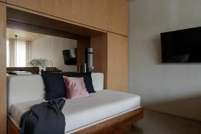 a bedroom with a white bed with blue and pink pillows at OXO Townhouses Berawa Canggu in Canggu