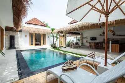 a villa with a swimming pool with chairs and an umbrella at Simple & Magical Villas VILLA SAMBALI in Seminyak