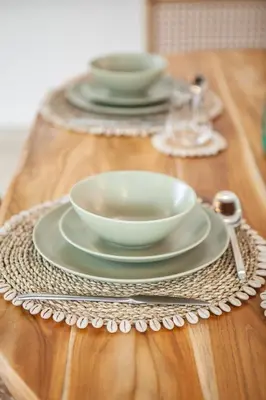 a table with plates and bowls on a wooden table at Simple & Magical Villas VILLA SAMBALI in Seminyak