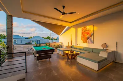a living room with a couch and a pool table at Hedonia Luxury Villas in Seminyak
