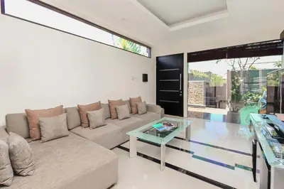 a living room with a couch and a glass table at Villa Cascade in Seminyak