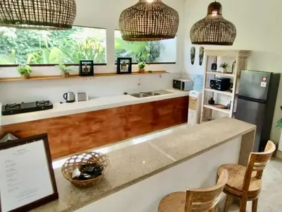 a kitchen with a counter with a sink and a refrigerator at Villa MONTI - LEGIAN - SEMINYAK - Lovely 2 Bedroom Villa - Great Location ! in Seminyak