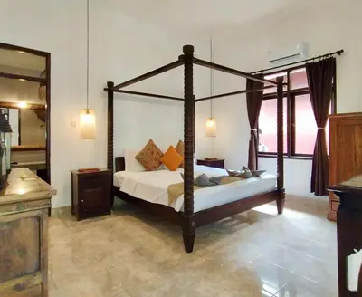 a bedroom with a canopy bed in a room at Villa MONTI - LEGIAN - SEMINYAK - Lovely 2 Bedroom Villa - Great Location ! in Seminyak