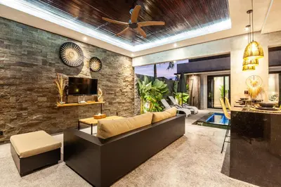 a living room with a couch and a brick wall at Simple And Magical . VILLA ALMAYA in Seminyak