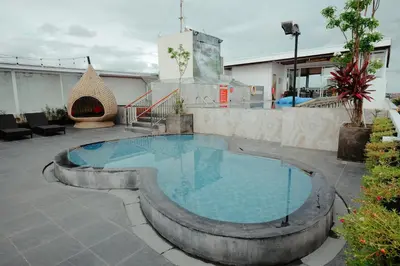 a swimming pool in the middle of a patio at Boss Legian Hotel Powered by Archipelago in Legian