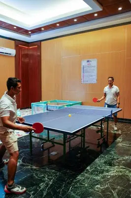 two men playing ping pong on a ping pong table at Boss Legian Hotel Powered by Archipelago in Legian