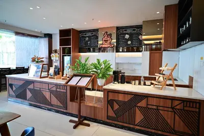 a restaurant with a counter with a menu on the wall at Boss Legian Hotel Powered by Archipelago in Legian