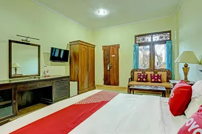 a bedroom with a large bed and a mirror at OYO Collection O 91125 Puri Dewa Bharata in Jimbaran
