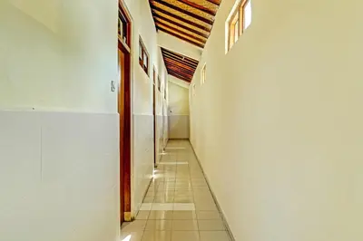 an empty hallway with a long corridor at OYO Collection O 91125 Puri Dewa Bharata in Jimbaran