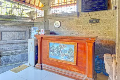 a painting on a wooden stand in a room at OYO Collection O 91125 Puri Dewa Bharata in Jimbaran