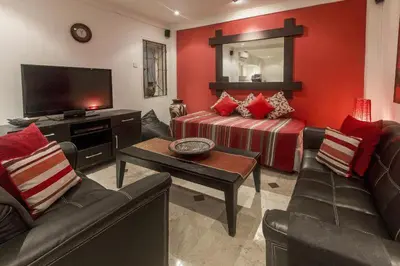 a living room with a couch and a tv at Cozy Bali Apartment in Seminyak