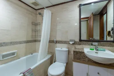 a bathroom with a toilet and a sink and a tub at Cozy Bali Apartment in Seminyak