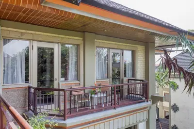 a house with a balcony with windows at Cozy Bali Apartment in Seminyak