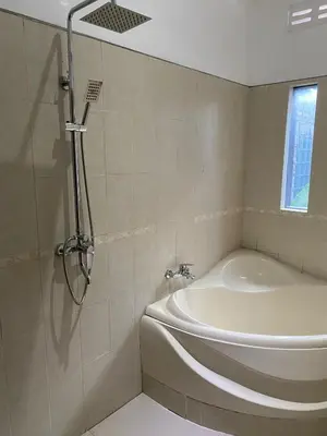a bathroom with a shower and a bath tub at Villa Tenang Legian in Legian