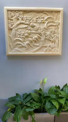 a wooden picture on a white wall with plants at Villa Tenang Legian in Legian