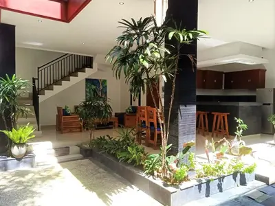 a living room with plants and a staircase at Villa Tenang Legian in Legian