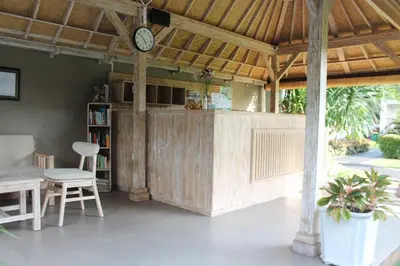 a kitchen with a table and a clock on the wall at Green D'mel Bali in Nusa Dua