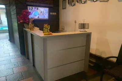 a counter in a room with flowers on it at DENAYS GUESTHOUSE JIMBARAN in Jimbaran