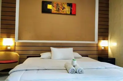 a bedroom with a bed with two towels on it at DENAYS GUESTHOUSE JIMBARAN in Jimbaran