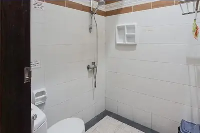 a bathroom with a toilet and a shower stall at DENAYS GUESTHOUSE JIMBARAN in Jimbaran